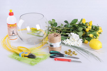 кругла ваза-акваріум   скляні декоративні камінчики   декоративна тканина з силуетами метеликів або квітів білого і зеленого кольорів   дріт   «Кільця мондоліно» (декоративна пофарбована лоза, що використовується у флористиці, її можна придбати в спеціалізованих салонах)   клей   ніж, ножиці і секатор   кущові троянди і нарциси (або інші невеликі квіти білого і жовтого кольору)   берграсс - жорстка декоративна трава   лимон